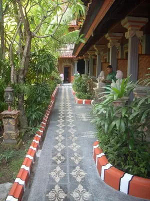 a walkway in front of a building with plants at Hotel Sorga Cottages in Kuta