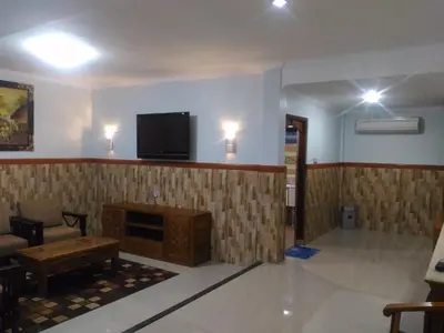 a living room with a fireplace and a tv on the wall at Hotel Sorga Cottages in Kuta
