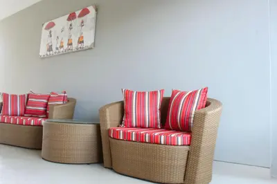 two wicker chairs and a table in a room at Rusty Seminyak in Seminyak