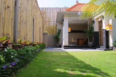 a backyard with a fence and a yard with flowers at Rusty Seminyak in Seminyak