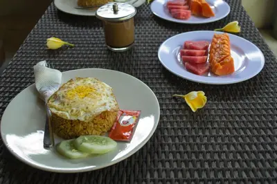 a table with plates of food and fruit on it at Flamboyan Hotel in Kuta