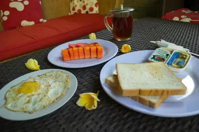 two plates of breakfast food on a table at Flamboyan Hotel in Kuta