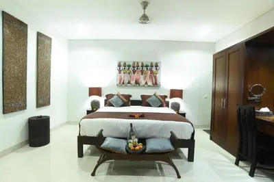 a bedroom with a bed and a chair in it at Villa Verde in Seminyak