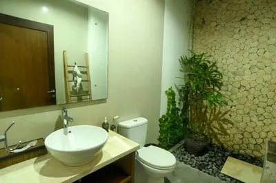 a bathroom with a sink and a toilet and a mirror at Villa Verde in Seminyak