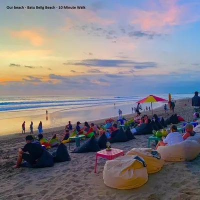a group of people sitting on the beach watching the sunset at Villa Verde in Seminyak
