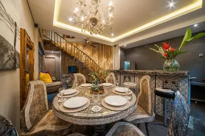 a dining room with a table and chairs and a chandelier at Luxury Villas Merci Resort 3BR Seminyak #2 in Kuta