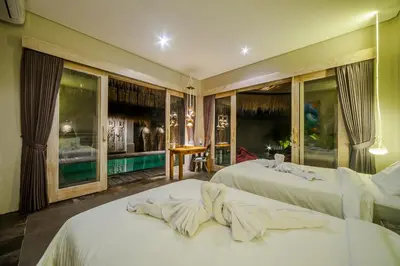 a hotel room with two beds and a large window at Luxury Villas Merci Resort 3BR Seminyak #2 in Kuta
