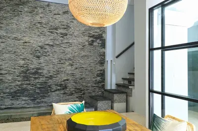 a dining room with a table and a large window at Origin Seminyak in Seminyak