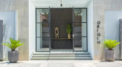 a front door of a building with two potted plants at Origin Seminyak in Seminyak
