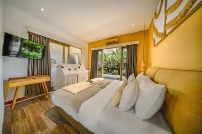 a bedroom with a large white bed and a window at La Mira Villa Seminyak by Ini Vie Hospitality in Seminyak