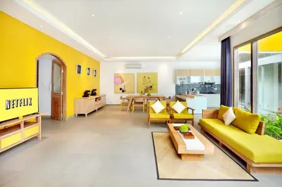 a living room with yellow walls and a yellow couch at La Mira Villa Seminyak by Ini Vie Hospitality in Seminyak
