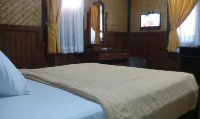 a bedroom with a bed and a tv in a room at Bali Diva Hotel Kuta in Kuta