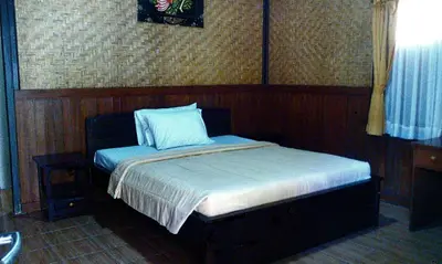 a bedroom with a bed with a blue pillow on it at Bali Diva Hotel Kuta in Kuta