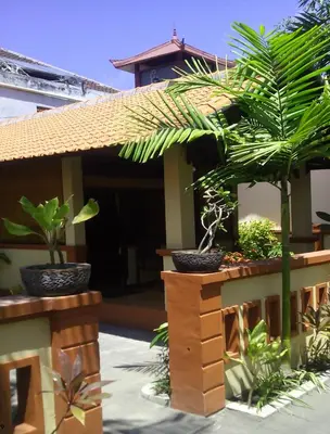 a house with two potted plants in front of it at Bali Diva Hotel Kuta in Kuta