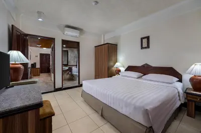 a bedroom with a large bed and a bathroom at The Jayakarta Bali Beach Resort in Legian