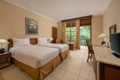 a hotel room with two beds and a television at The Jayakarta Bali Beach Resort in Legian