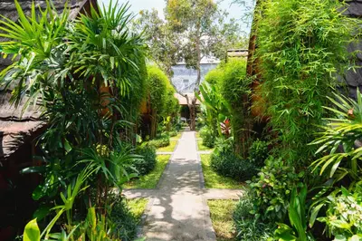 a path through a garden with trees and plants at Kubu Kak Dudung Villas in Jimbaran