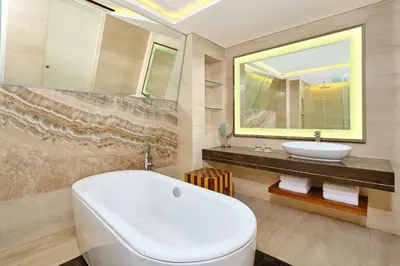 a bathroom with a white tub and a sink at Le Meridien Bali Jimbaran in Jimbaran