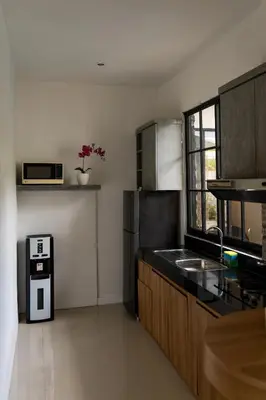 a kitchen with a sink and a refrigerator at Awila Villas Kuta by The Wina Resorts in Legian