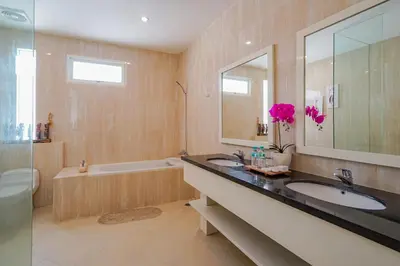 a bathroom with two sinks and a bath tub at Awila Villas Kuta by The Wina Resorts in Legian