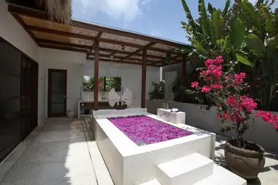 a patio with a large bed of purple flowers at Nyaman Villas Seminyak in Seminyak