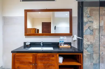 a bathroom with a sink and a mirror at De' Bharata Bali Villas in Seminyak