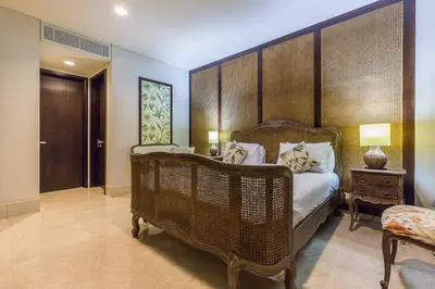 a bedroom with a large bed with a wooden headboard at Villa Deh Simba at Ayana With Private Pool in Jimbaran