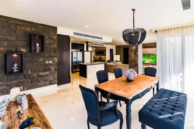 a kitchen and living room with a wooden table and chairs at Villa Deh Simba at Ayana With Private Pool in Jimbaran