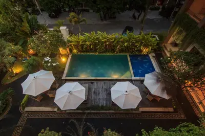 an overhead view of a swimming pool with umbrellas at Pondok Anyar Hotel in Kuta