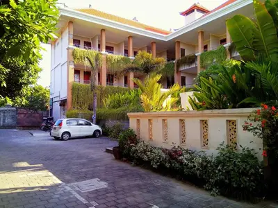 a white car parked in front of a building at Pondok Anyar Hotel in Kuta