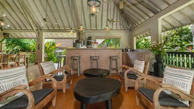 a restaurant with a table and chairs and a bar at Villa Koyama by Villa Finder in Seminyak