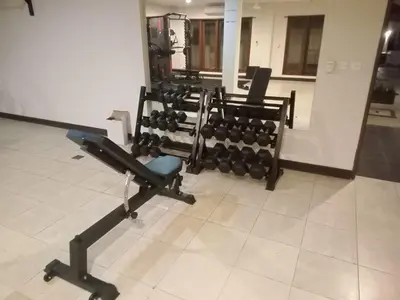 a gym with a row of dumbbells at Kuta Town House Apartments in Kuta