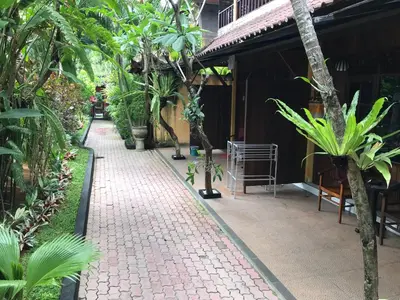a brick walkway in front of a building with trees at De Puspa Residence Seminyak in Seminyak