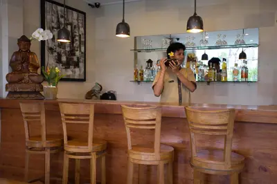 a man taking a picture at a bar at Sandi Agung Villa in Seminyak