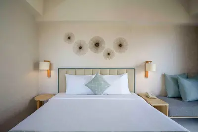 a bedroom with a large white bed with two mirrors on the wall at Solaris Hotel Kuta in Kuta