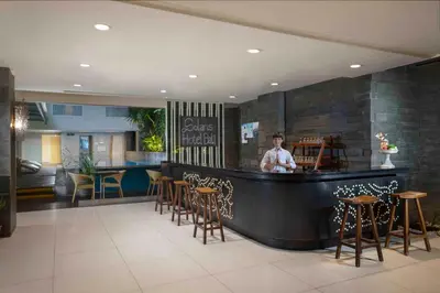 a man standing behind a bar in a restaurant at Solaris Hotel Kuta in Kuta
