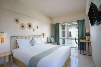 a bedroom with a large bed and a television at Solaris Hotel Kuta in Kuta