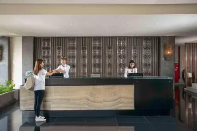 two people standing at a counter in a hotel lobby at Solaris Hotel Kuta in Kuta