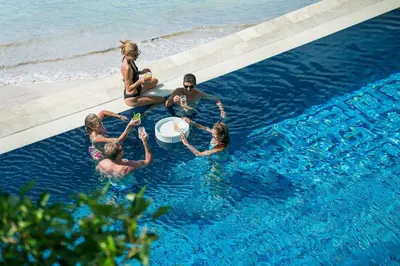 a group of people in a pool with a frisbee at Four Seasons Resort Bali at Jimbaran Bay in Jimbaran