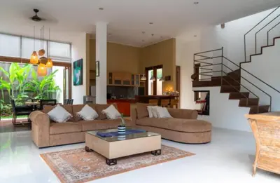 a living room with two couches and a staircase at VILLA DUNA Seminyak Bali in Seminyak