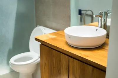 a bathroom with a sink and a toilet on a wooden counter at VILLA DUNA Seminyak Bali in Seminyak