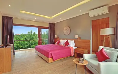 a hotel room with a bed and a couch at Kubu GWK Resort in Jimbaran