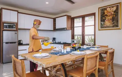 a man standing in a kitchen with a table at Kubu GWK Resort in Jimbaran
