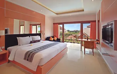 a bedroom with a large bed and a television at Kubu GWK Resort in Jimbaran