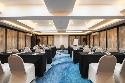 a conference room with tables and chairs and a podium at Bali Dynasty Resort in Kuta