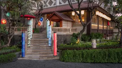 a building with a staircase in front of a house at Hotel Nikko Bali Benoa Beach in Nusa Dua