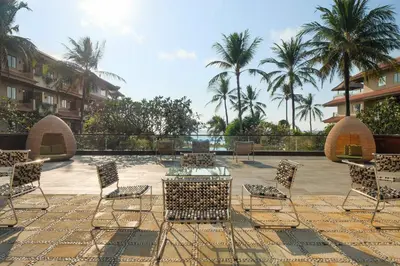 a patio with chairs and a table with a view of the ocean at Hotel Nikko Bali Benoa Beach in Nusa Dua