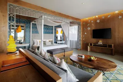 a living room with a bed and a couch and a tv at Hotel Nikko Bali Benoa Beach in Nusa Dua
