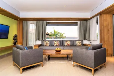 a living room with a couch and a table and chairs at Hotel Nikko Bali Benoa Beach in Nusa Dua