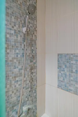 a shower with a shower head in a bathroom at Dream @ Jimbaran in Jimbaran